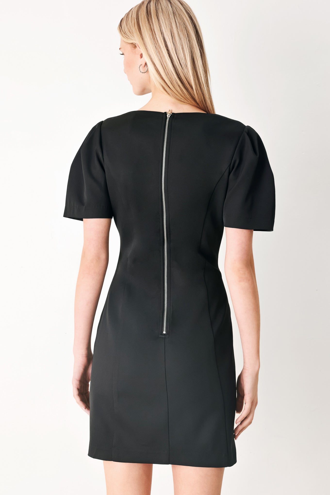 Woman wearing a black mini dress featuring round neckline, short sleeve and back zipper closure | FREEMARKET