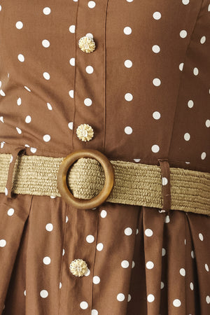 Woman wearing a brown with white polka dot midi dress featuring straight neckline, straps, button down detail, contrasting belt, full skirt and back zipper closure | FREEMARKET