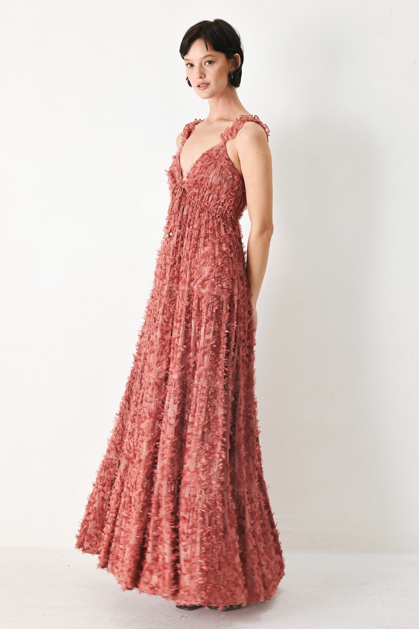 Woman wearing a rose pink textured maxi dress featuring cami top, ruffled straps, front tie, empire waist and tier skirt | FREEMARKET