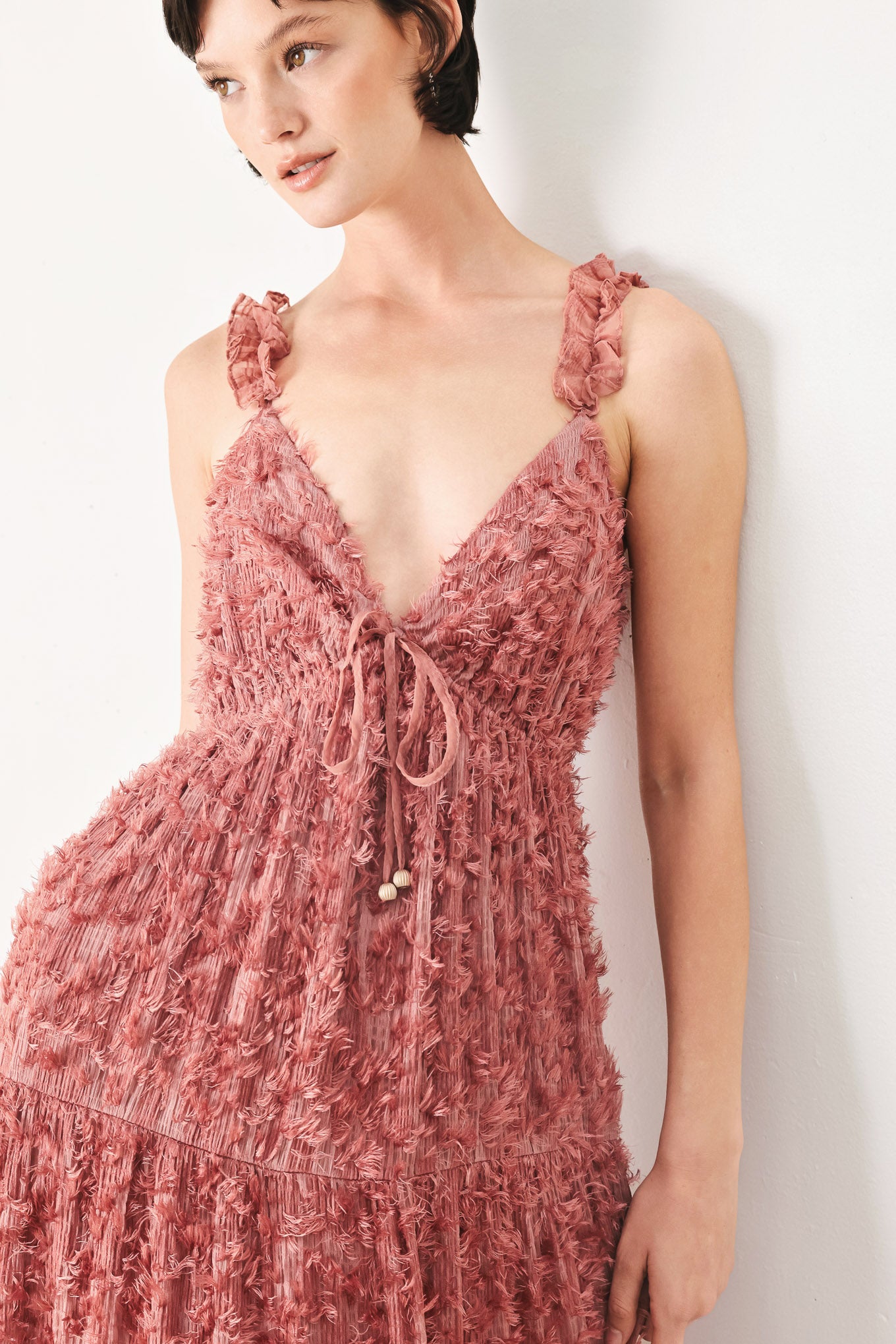 Woman wearing a rose pink textured maxi dress featuring cami top, ruffled straps, front tie, empire waist and tier skirt | FREEMARKET