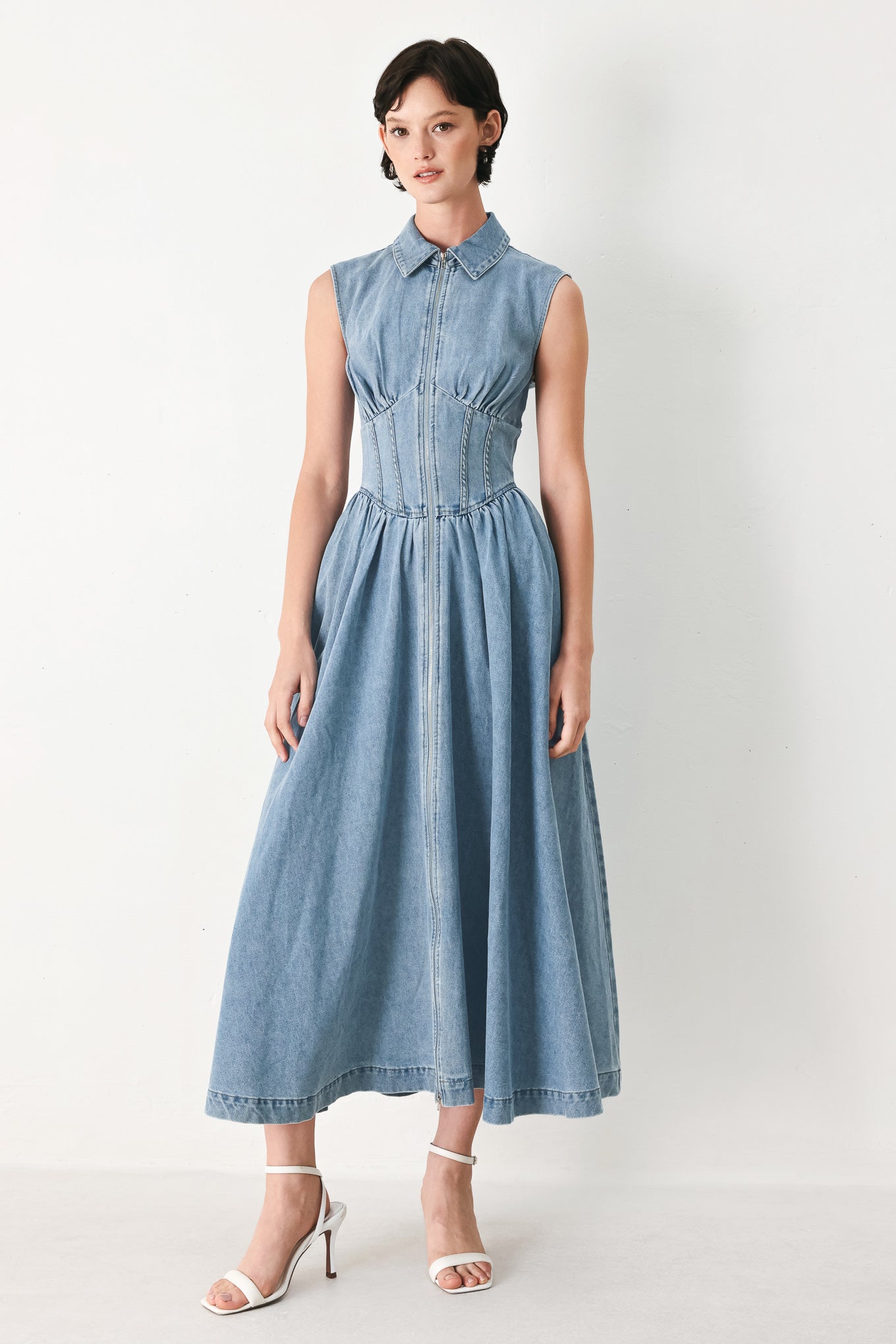 Woman wearing a denim midi dress with collar, sleeveless, front zipper closure, corset waist and full skirt | FREEMARKET