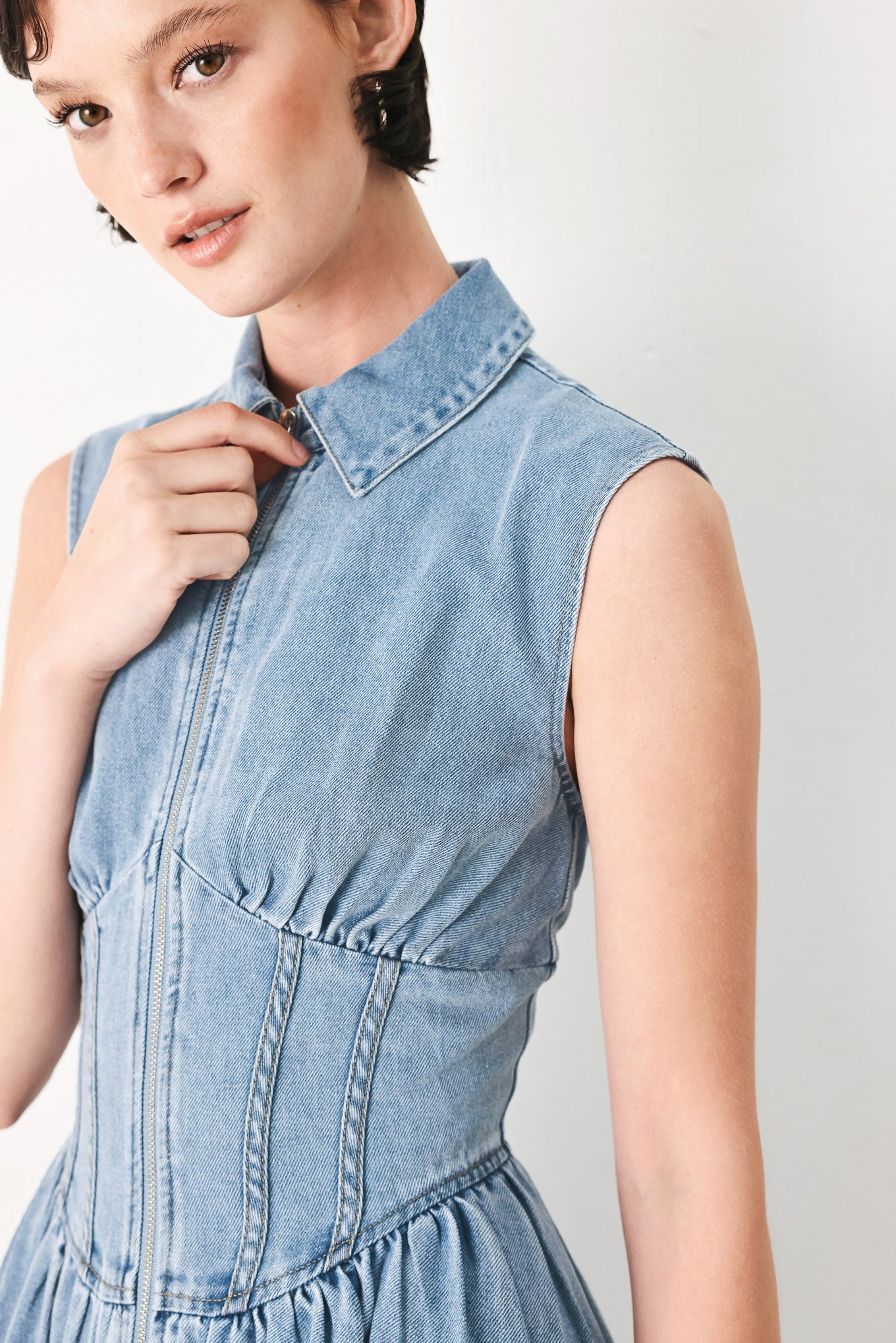 Woman wearing a denim midi dress with collar, sleeveless, front zipper closure, corset waist and full skirt | FREEMARKET