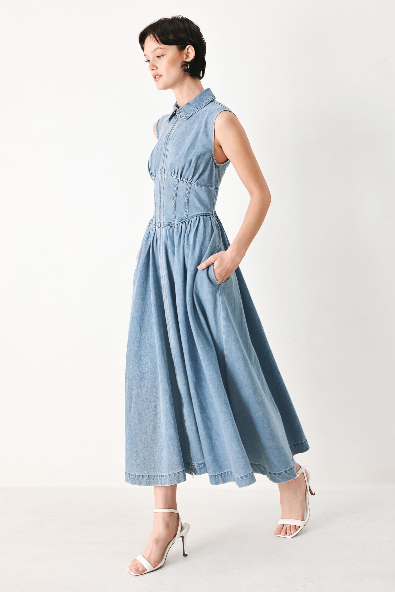 Woman wearing a denim midi dress with collar, sleeveless, front zipper closure, corset waist and full skirt | FREEMARKET