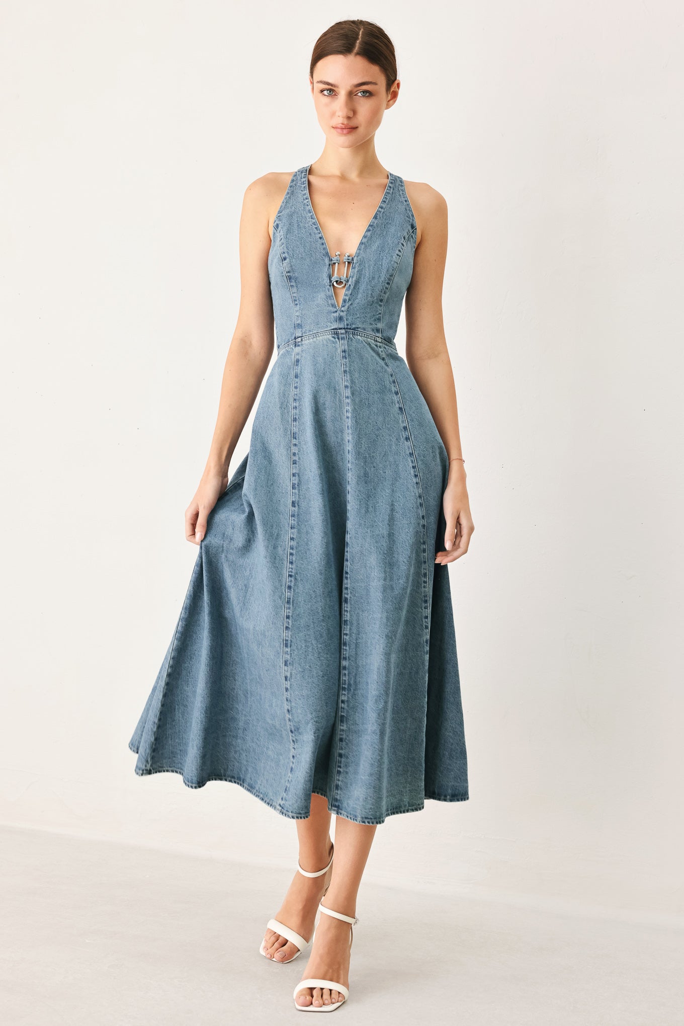 Woman wearing a blue denim dress on a white background