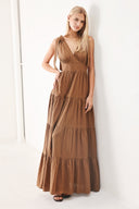 Woman wearing a brown tiered maxi dress featuring V neckline, shoulder ties, tier skirt and smocked back waistband | FREEMARKET