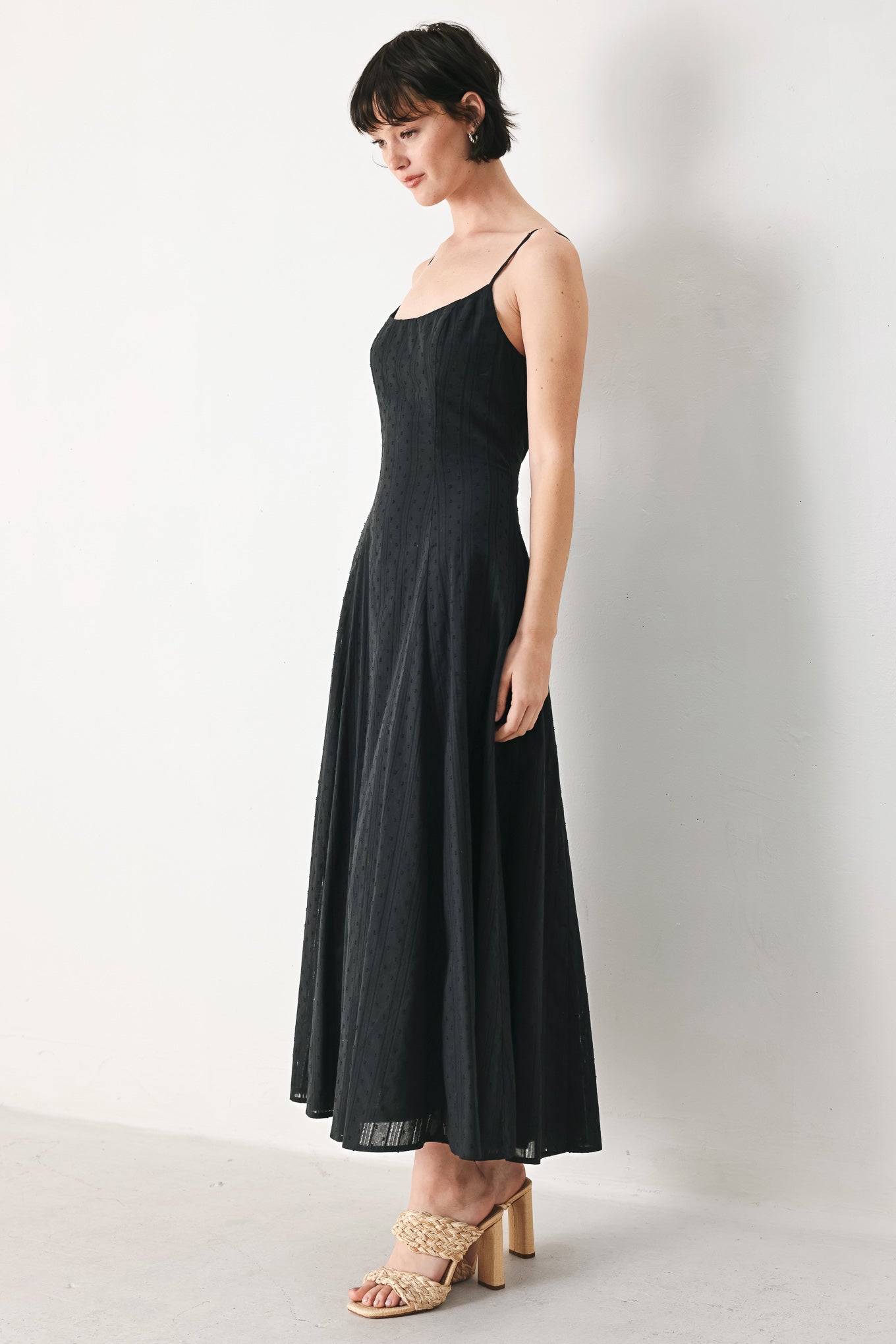 Woman wearing a black midi dress with straps, circle skirt and back zipper closure | FREEMARKET