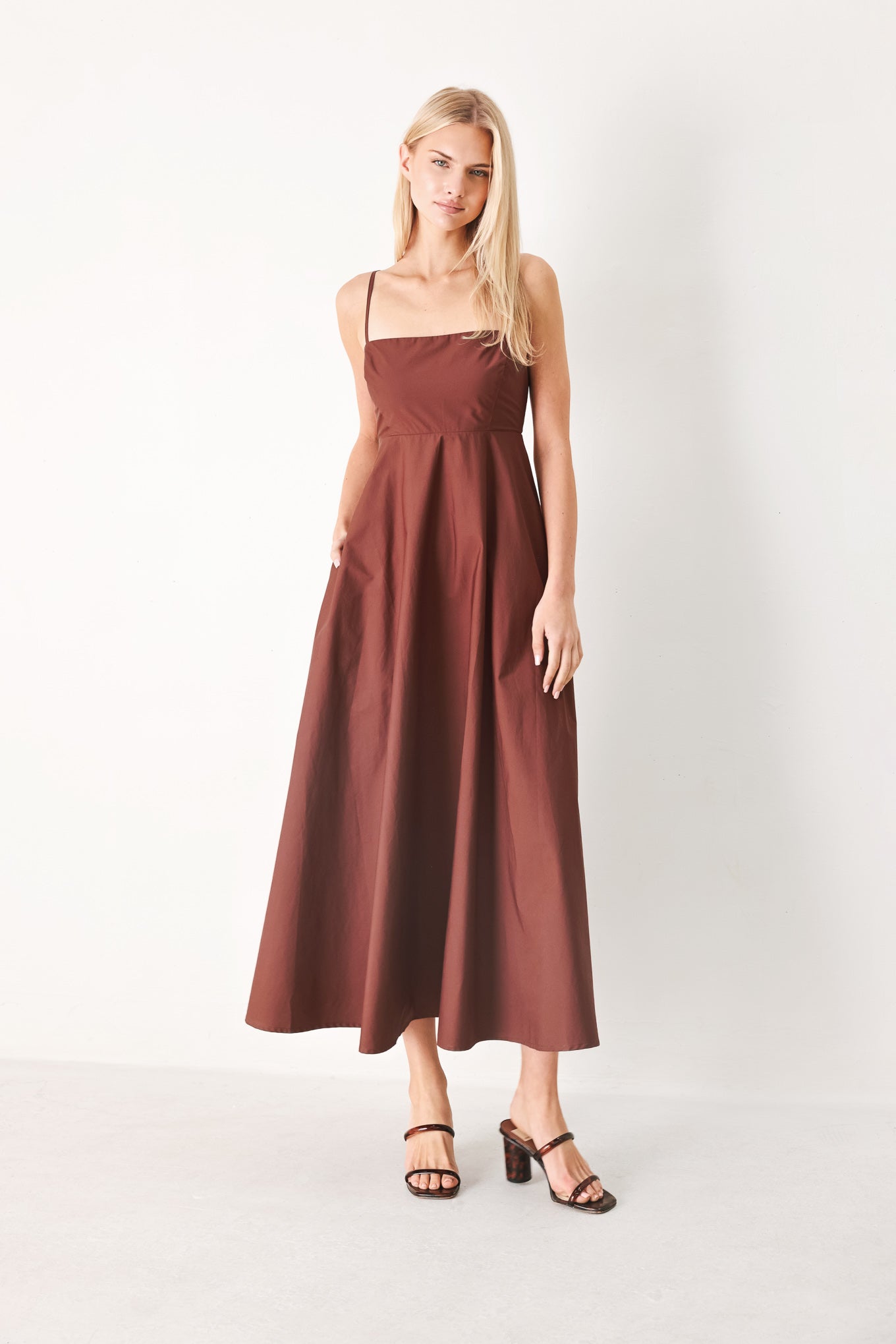 Woman wearing a dark rose midi dress featuring straight neckline, straps, circle skirt and back zipper closure | FREEMARKET