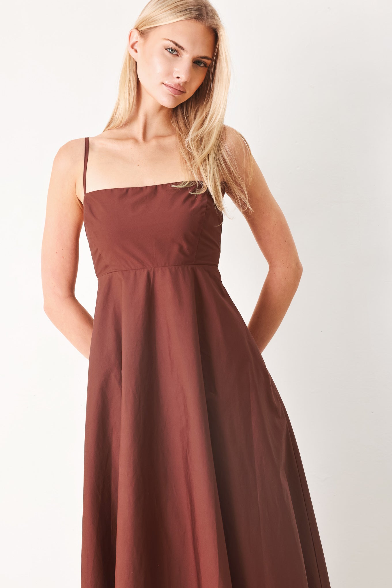 Woman wearing a dark rose midi dress featuring straight neckline, straps, circle skirt and back zipper closure | FREEMARKET
