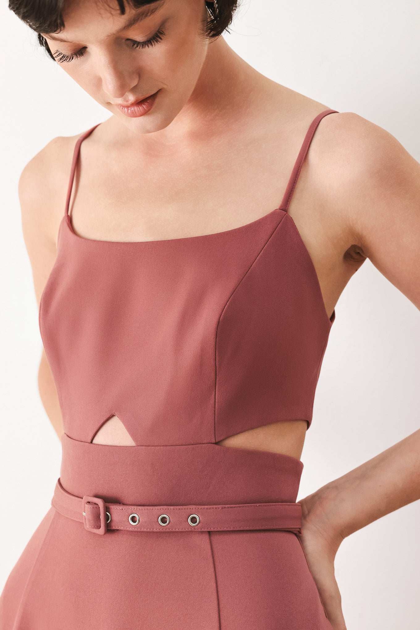 Woman wearing a rose pink midi dress with cut-out design featuring cam top, cut out at waistline, self belt, circle skirt and back zipper closure | FREEMARKET