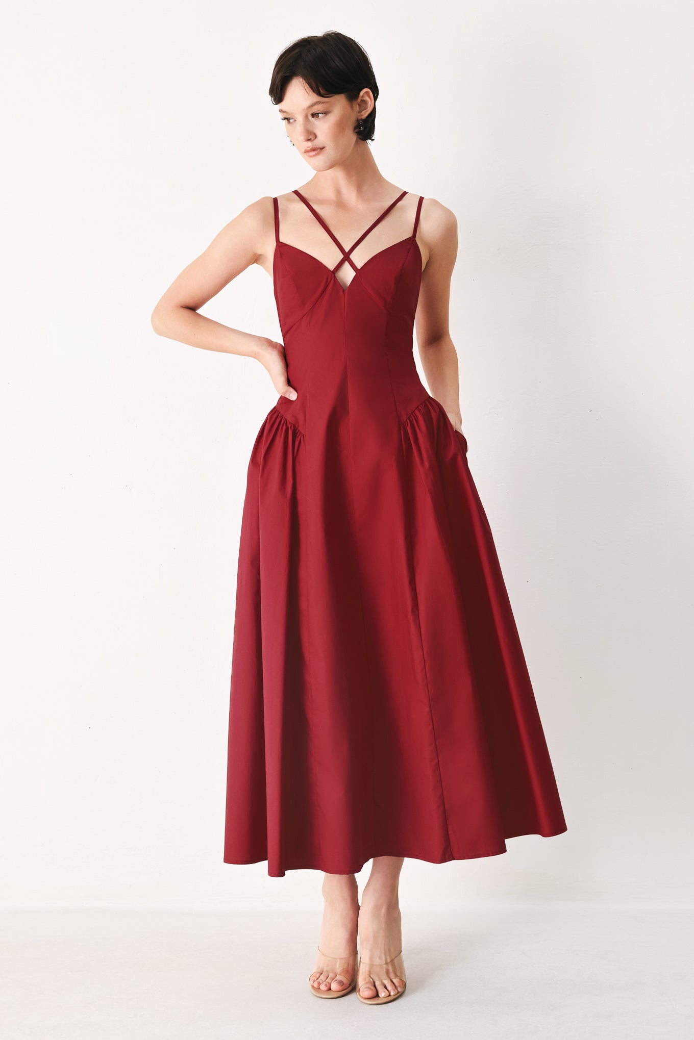 Woman wearing a deep red midi dress featuring cami top with double strap, side shirred skirt and back zipper closure | FREEMARKET