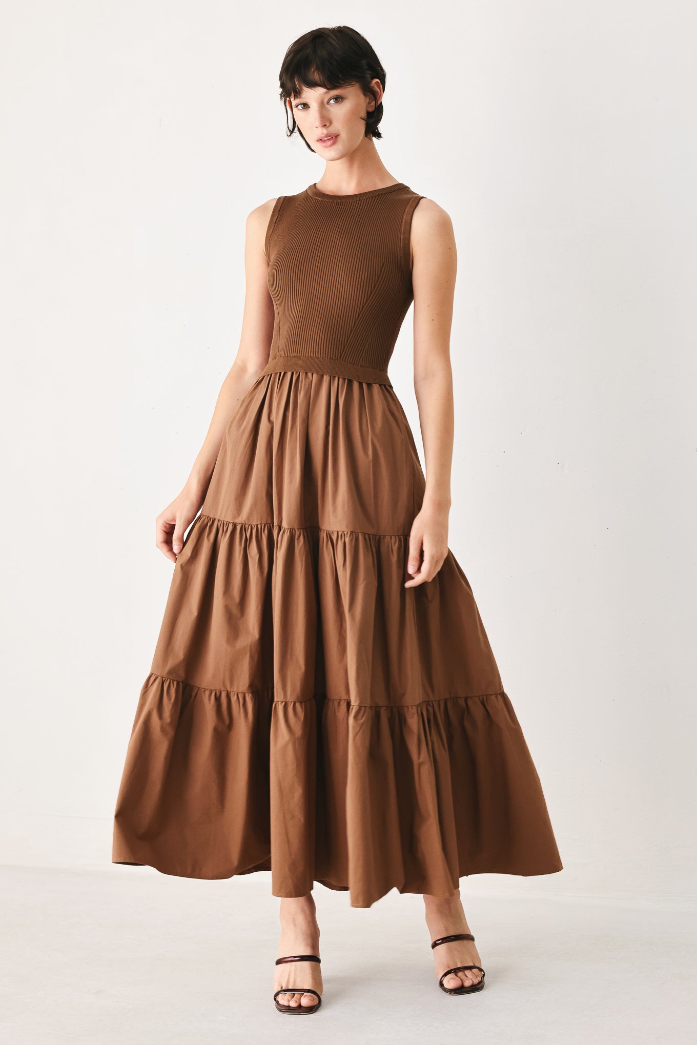 Woman wearing a brown sleeveless  sweater knit and woven mix midi dress featuring round neckline and tier skirt | FREEMARKET