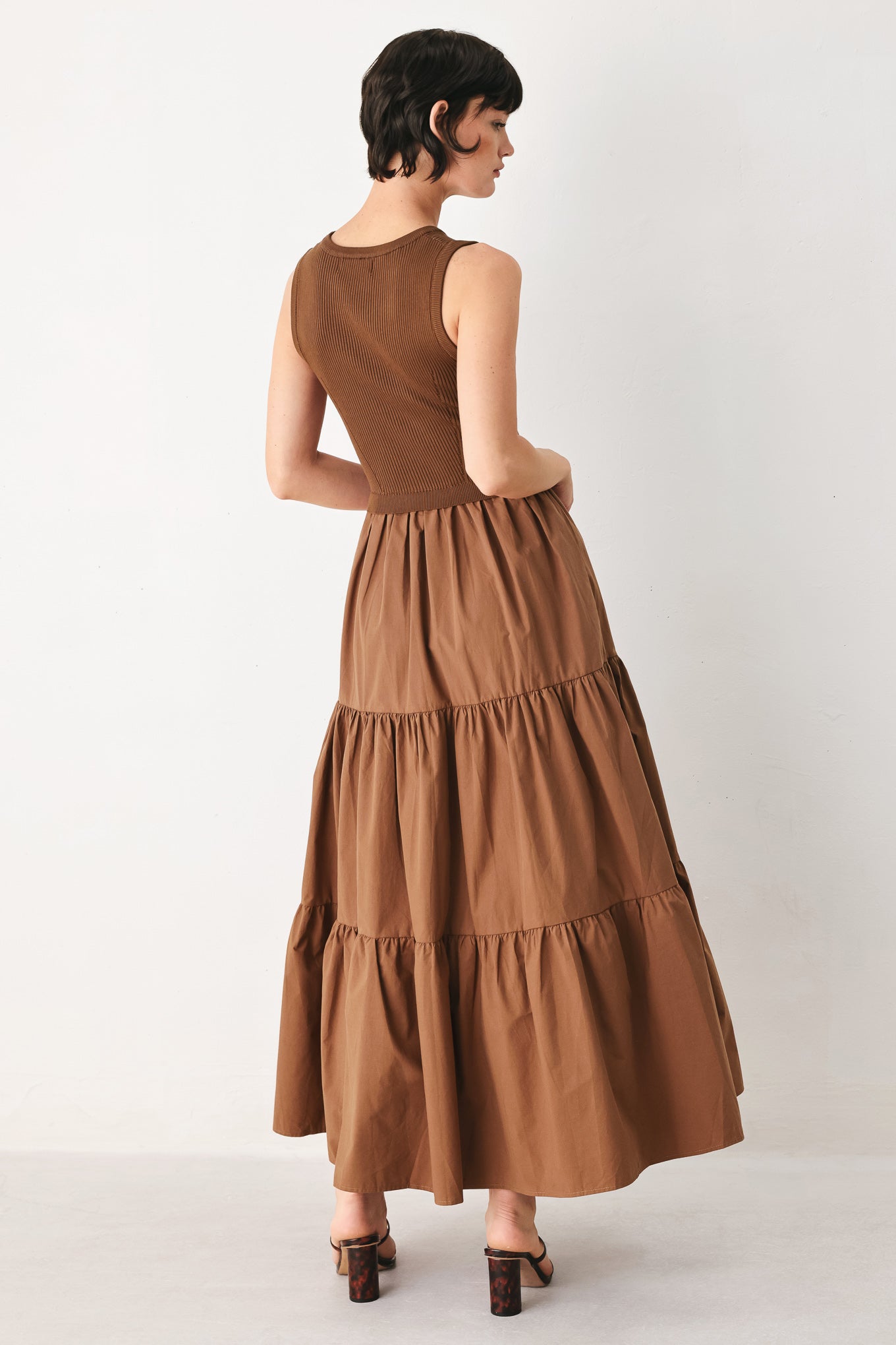 Woman wearing a brown sleeveless  sweater knit and woven mix midi dress featuring round neckline and tier skirt | FREEMARKET