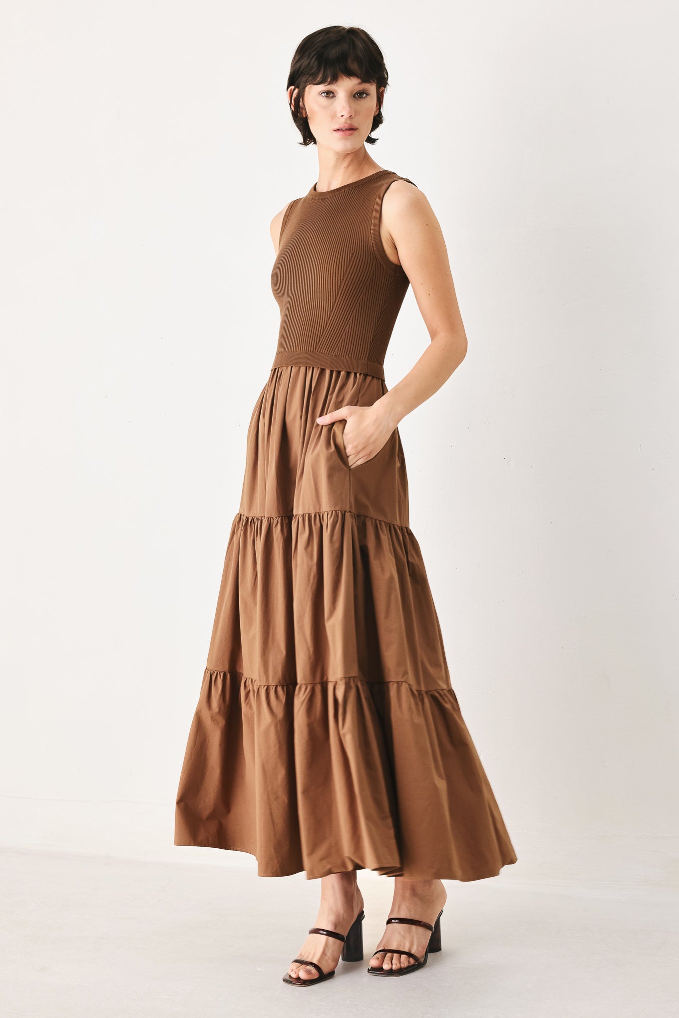 Woman wearing a brown sleeveless  sweater knit and woven mix midi dress featuring round neckline and tier skirt | FREEMARKET