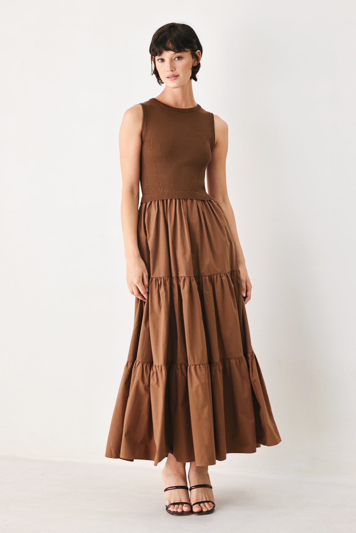 Woman wearing a brown sleeveless  sweater knit and woven mix midi dress featuring round neckline and tier skirt | FREEMARKET