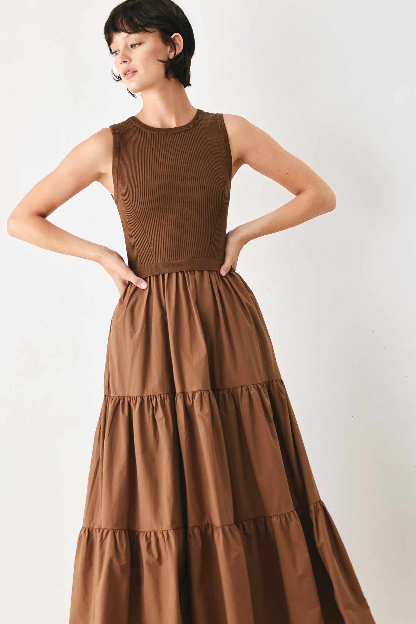 Woman wearing a brown sleeveless  sweater knit and woven mix midi dress featuring round neckline and tier skirt | FREEMARKET