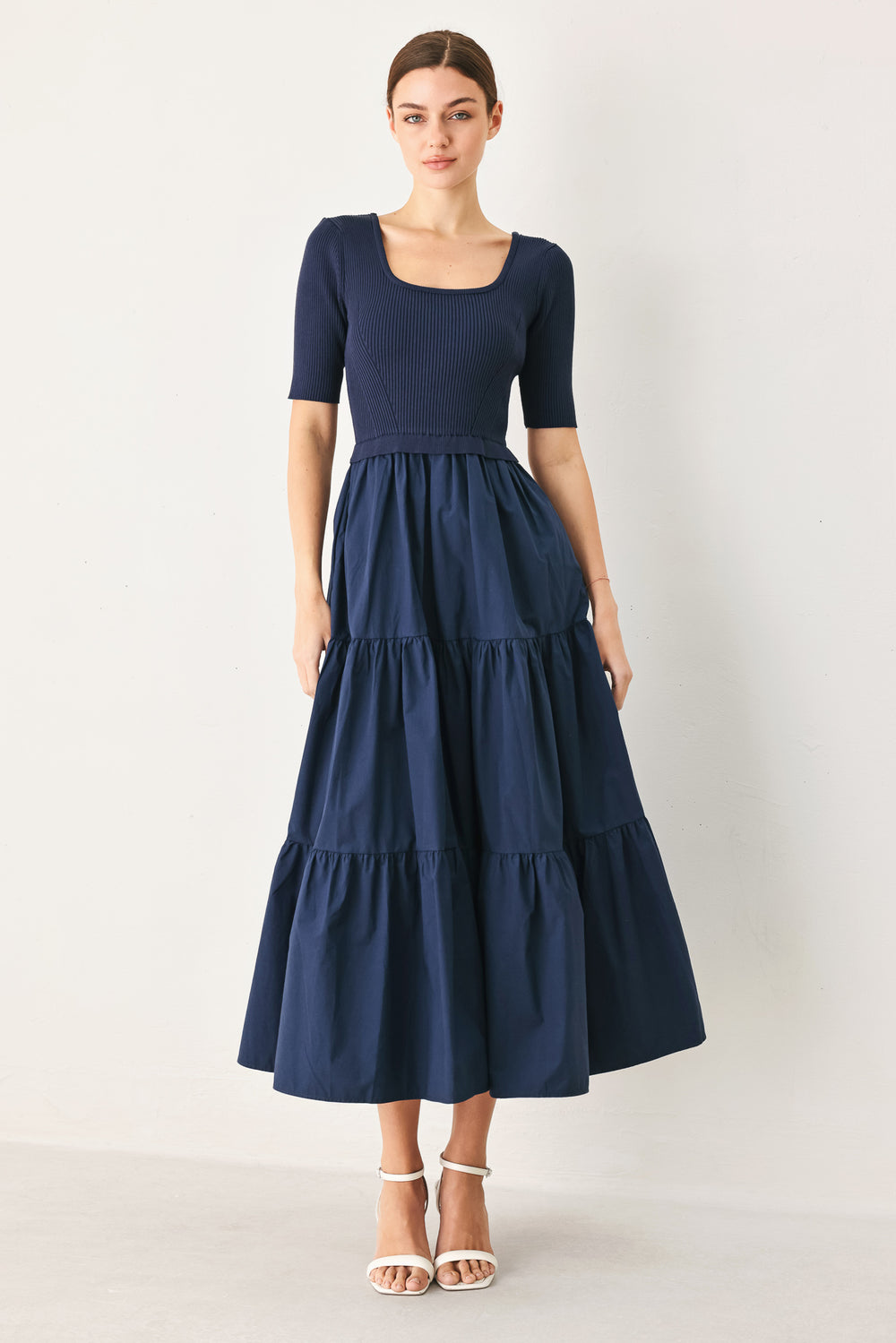 Woman wearing a solid sweater knit and woven mix navy blue midi dress featuring square neckline, short sleeve and tier skirt | FREEMARKET
