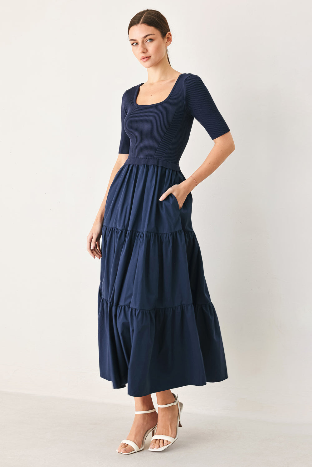Woman wearing a solid sweater knit and woven mix navy blue midi dress featuring square neckline, short sleeve and tier skirt | FREEMARKET