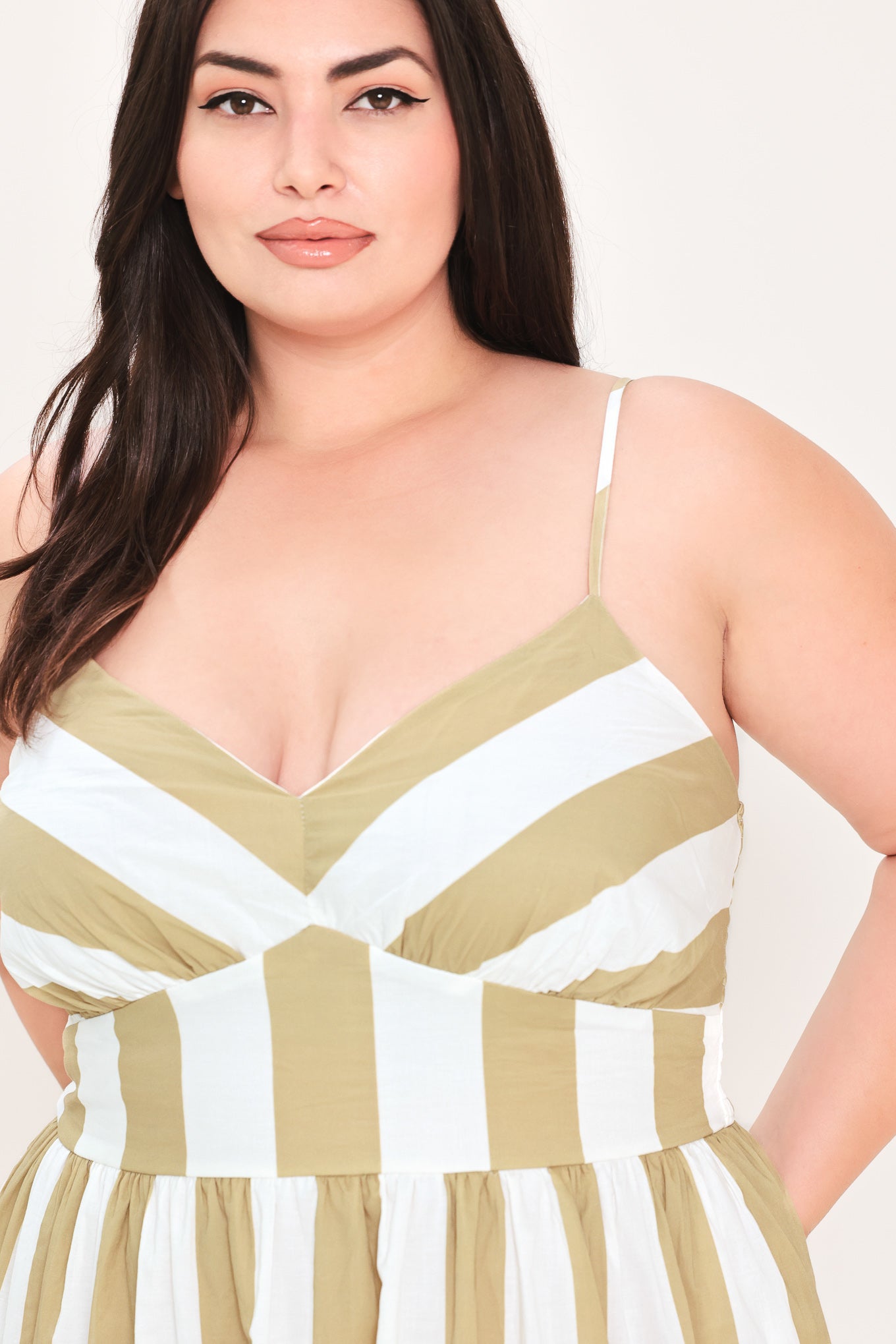 Woman wearing a taupe and white striped maxi dress | FREEMARKET Curve