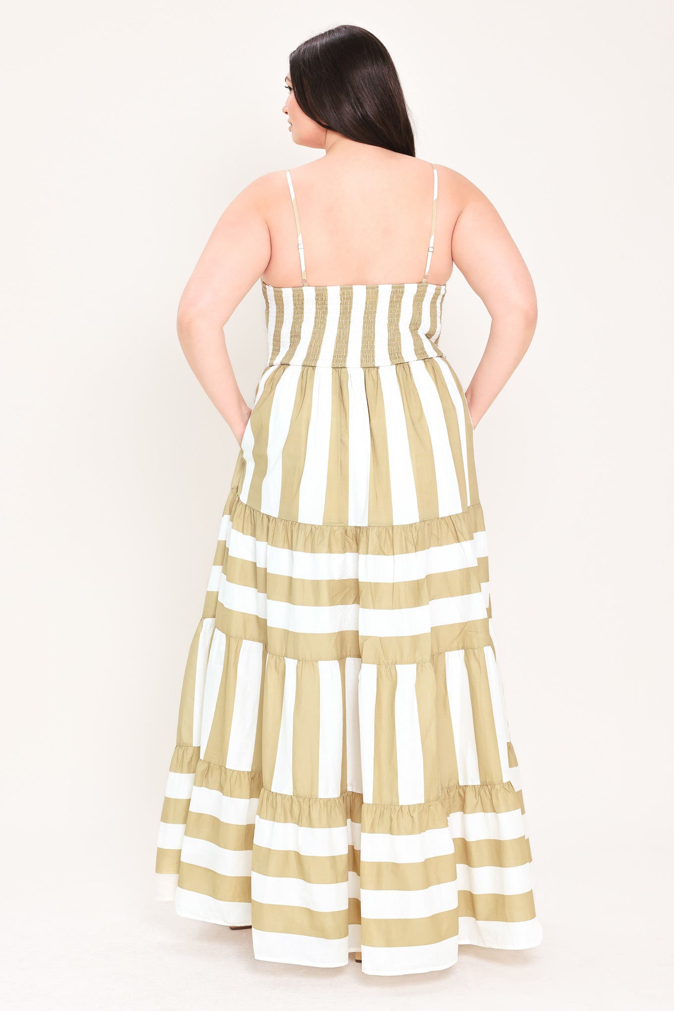 Woman wearing a taupe and white striped maxi dress | FREEMARKET Curve