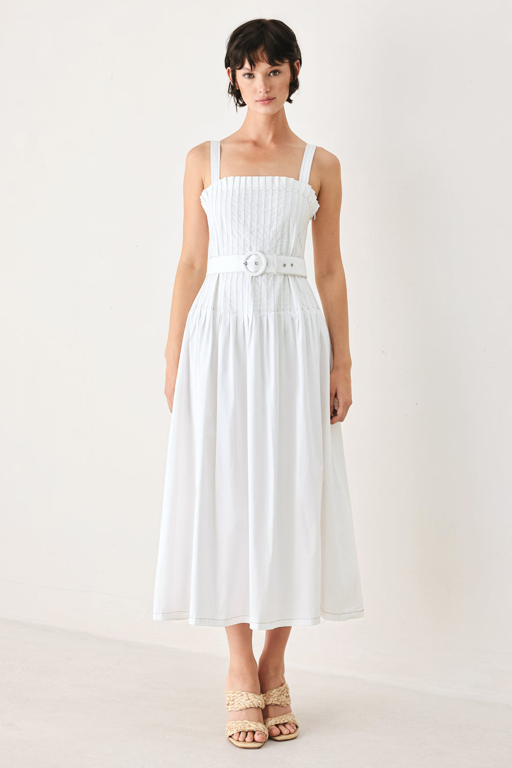 Woman wearing a white midi dress featuring straight neckline, straps, pintuck bodice, self belt and side zipper closure | FREEMARKET