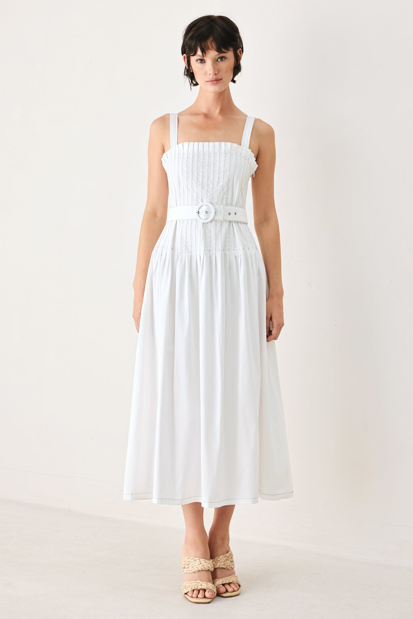 Woman wearing a white midi dress featuring straight neckline, straps, pintuck bodice, self belt and side zipper closure | FREEMARKET