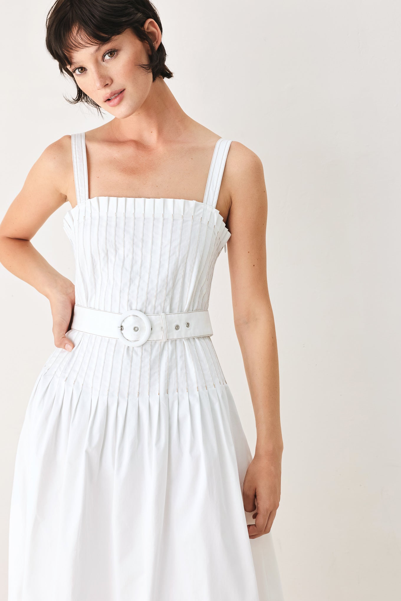 Woman wearing a white midi dress featuring straight neckline, straps, pintuck bodice, self belt and side zipper closure | FREEMARKET