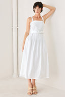 Woman wearing a white midi dress featuring straight neckline, straps, pintuck bodice, self belt and side zipper closure | FREEMARKET