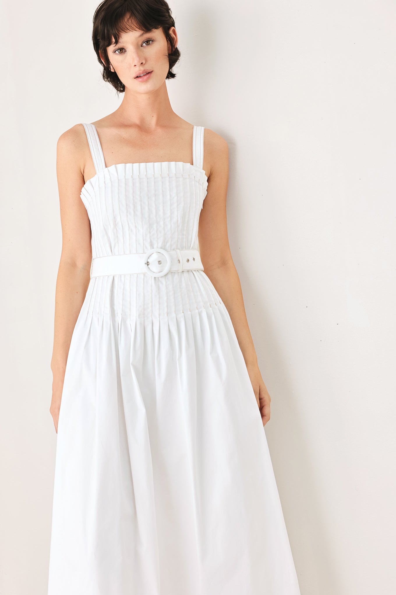 Woman wearing a white midi dress featuring straight neckline, straps, pintuck bodice, self belt and side zipper closure | FREEMARKET