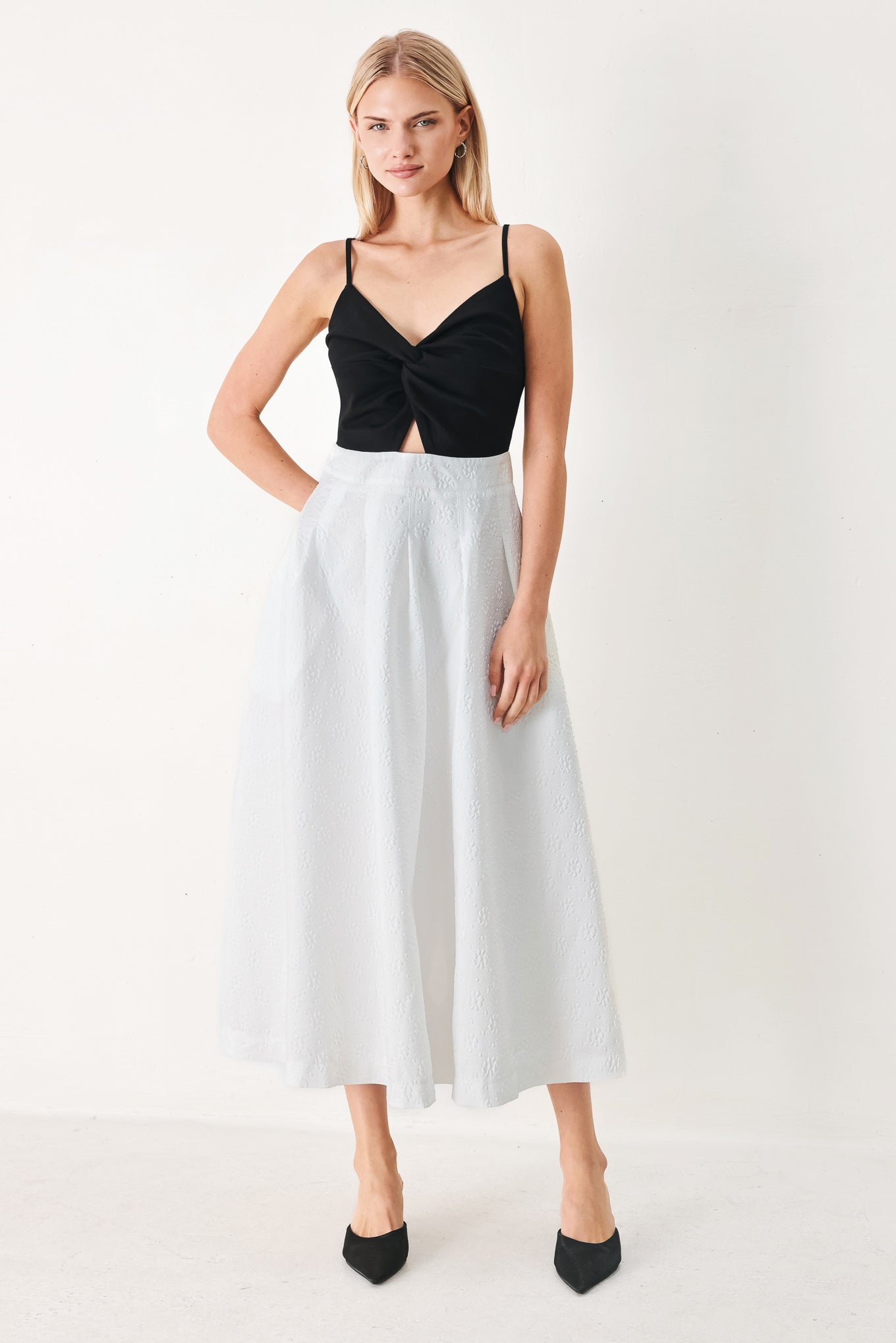 Woman wearing a black top and white midi dress featuring knit top with front twist and cut out, textured full skirt with pockets and back zipper closure | FREEMARKET