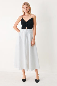 Woman wearing a black top and white midi dress featuring knit top with front twist and cut out, textured full skirt with pockets and back zipper closure | FREEMARKET