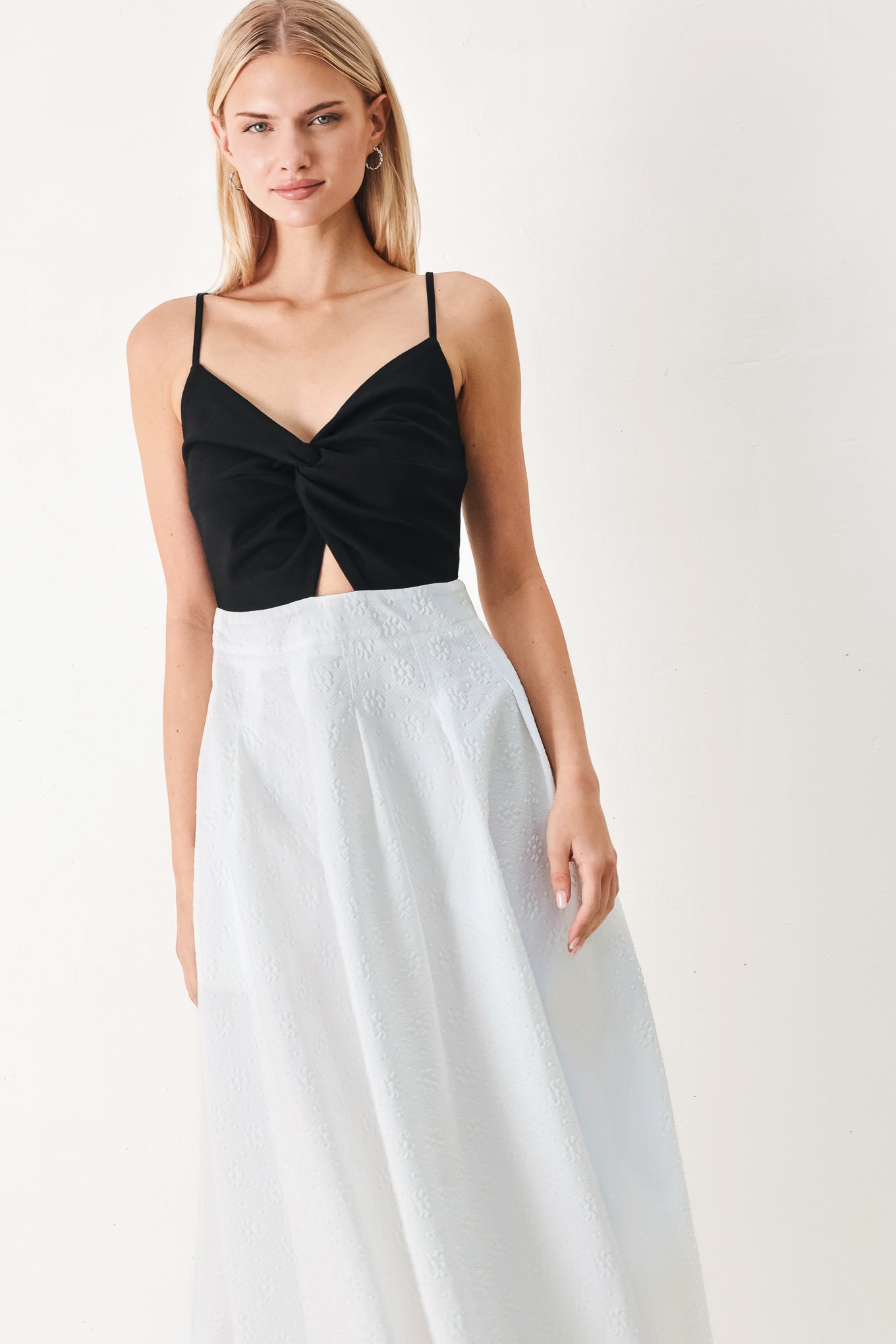 Woman wearing a black top and white midi dress featuring knit top with front twist and cut out, textured full skirt with pockets and back zipper closure | FREEMARKET