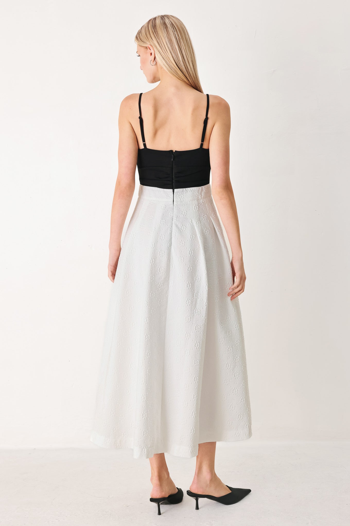 Woman wearing a black top and white midi dress featuring knit top with front twist and cut out, textured full skirt with pockets and back zipper closure | FREEMARKET