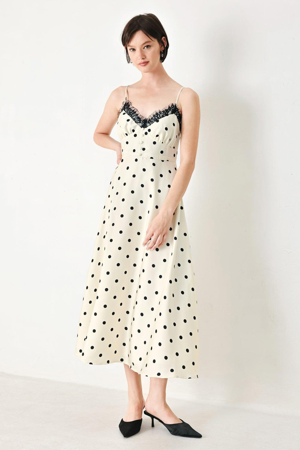A printed woven midi dress featuring cami top with lace trim, straps, waist yoke with buttons, circle skirt and back zipper closure