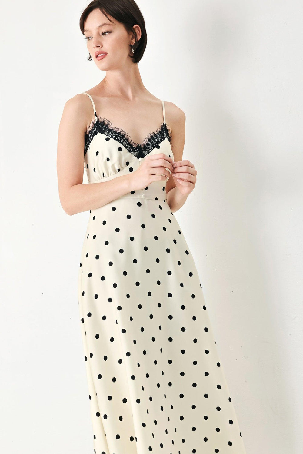 A printed woven midi dress featuring cami top with lace trim, straps, waist yoke with buttons, circle skirt and back zipper closure