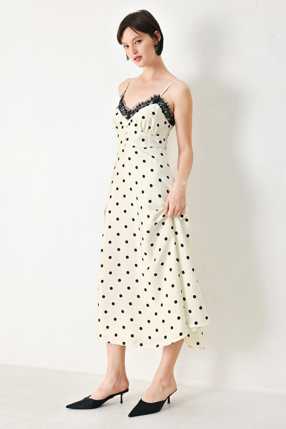 A printed woven midi dress featuring cami top with lace trim, straps, waist yoke with buttons, circle skirt and back zipper closure