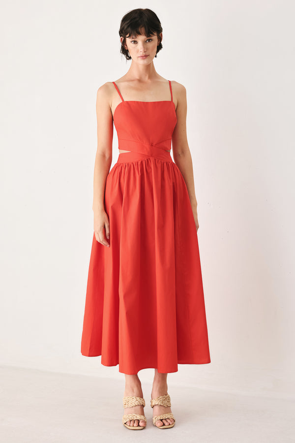 Woman wearing a red midi dress featuring straight neckline, straps, waist cutout, full skirt, and tie detail | FREEMARKET