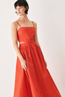 Woman wearing a red midi dress featuring straight neckline, straps, waist cutout, full skirt, and tie detail | FREEMARKET
