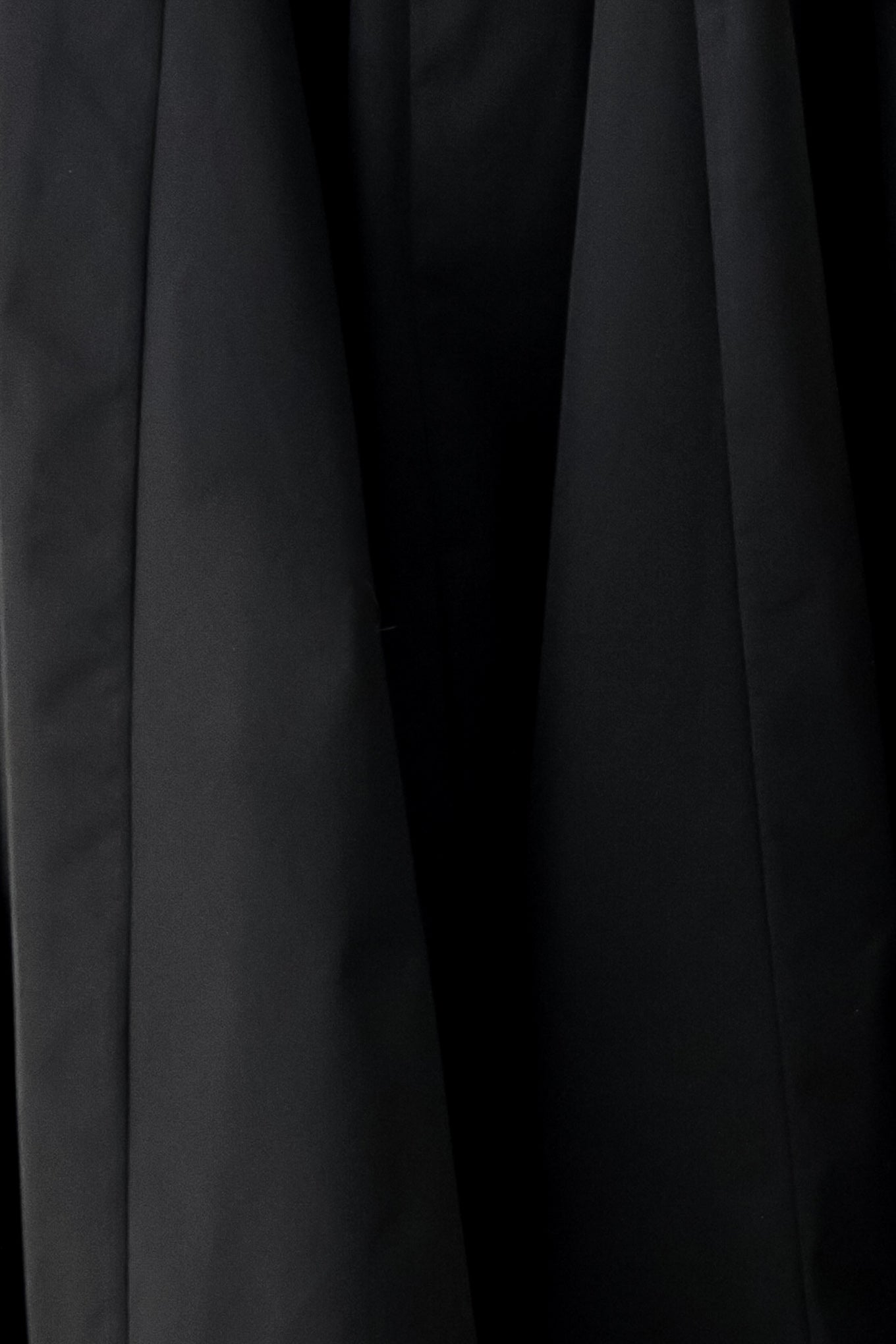 A woman modeling a black midi dress with thin spaghetti straps, a structured square neckline, and a flared skirt | FREEMARKET