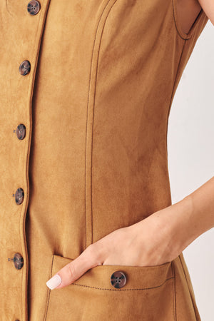 A woman wearing a sleeveless caramel dress with a front button placket and two front patch pockets | FREEMARKET