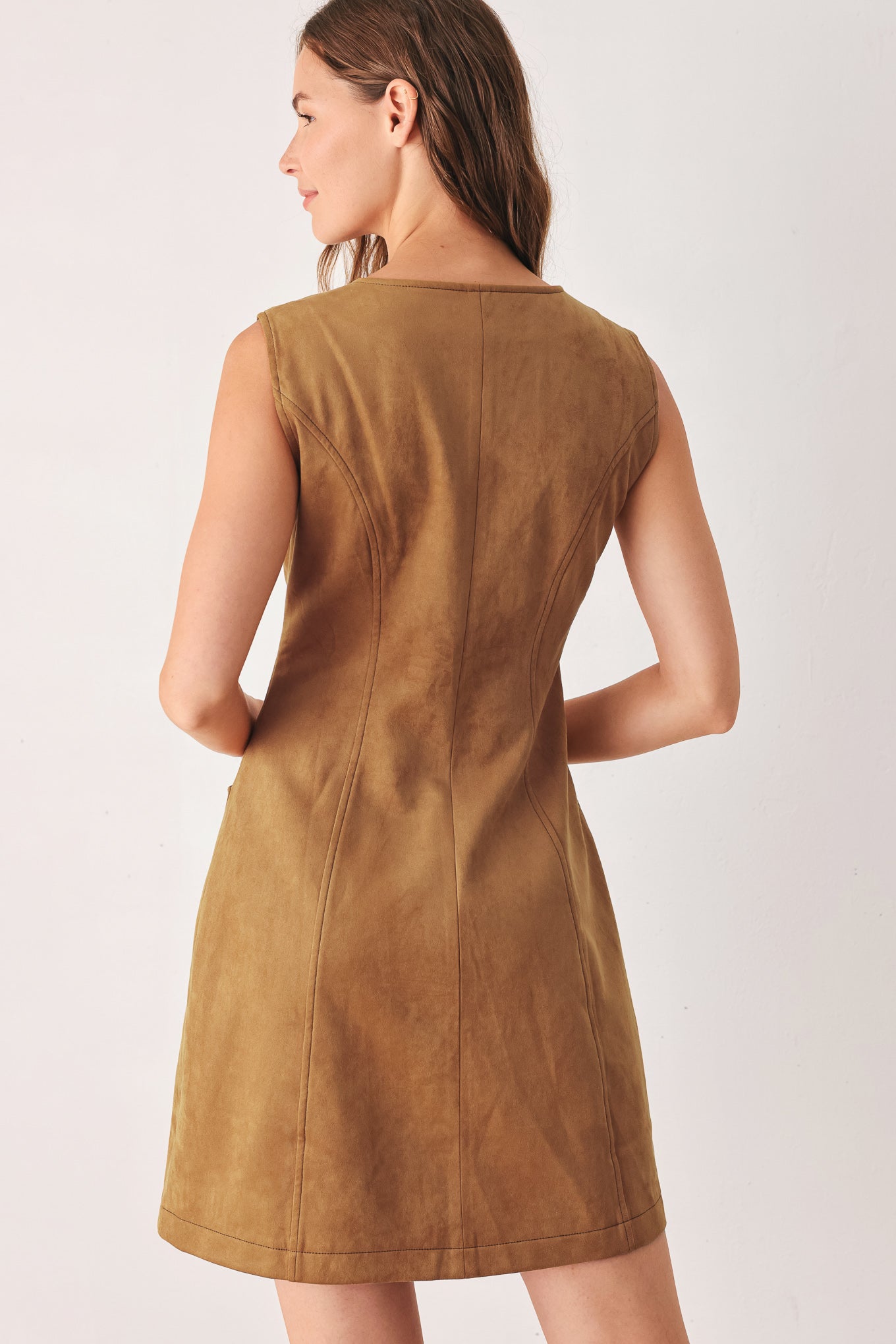 A woman wearing a sleeveless caramel dress with a front button placket and two front patch pockets | FREEMARKET