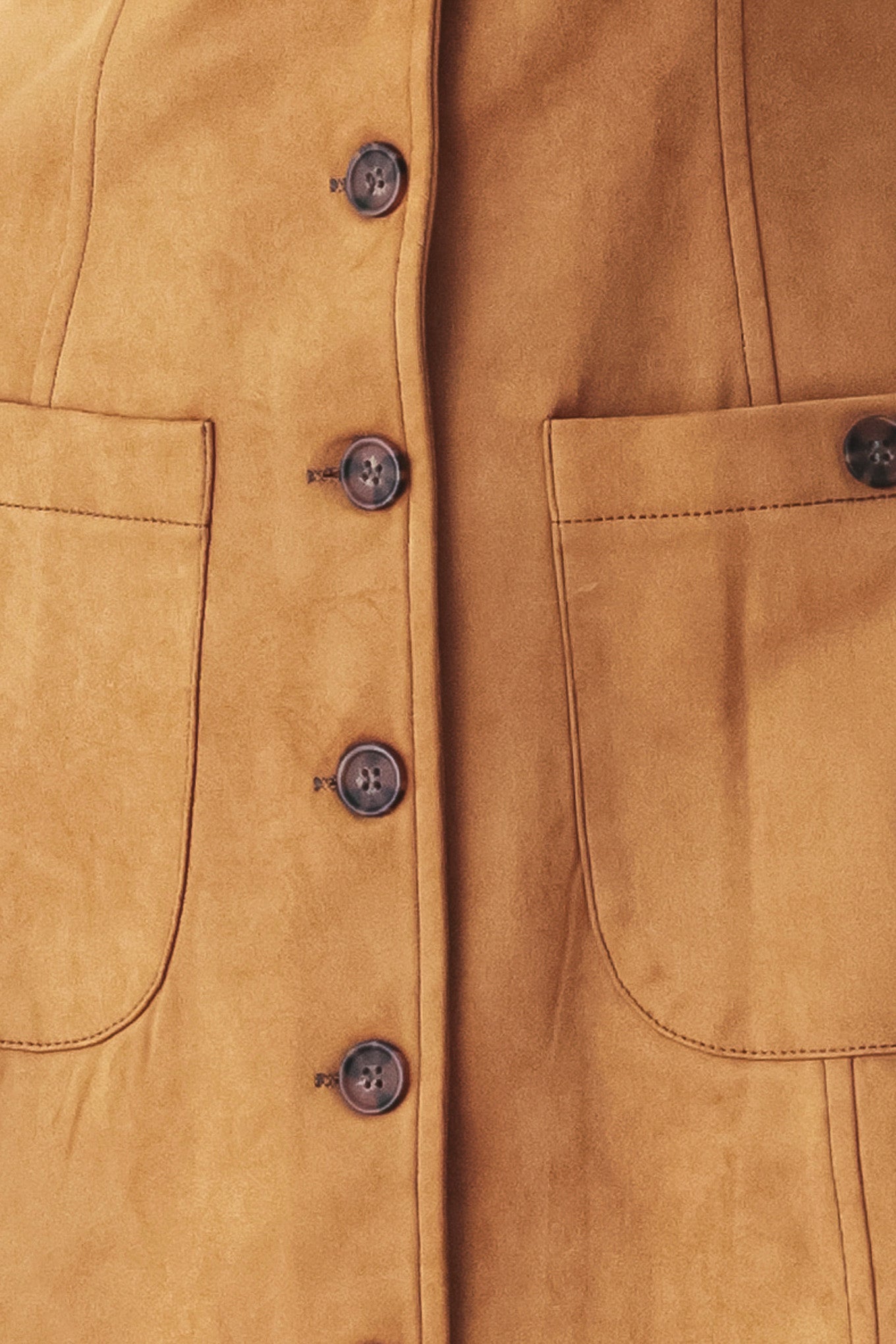 A woman wearing a sleeveless caramel dress with a front button placket and two front patch pockets | FREEMARKET