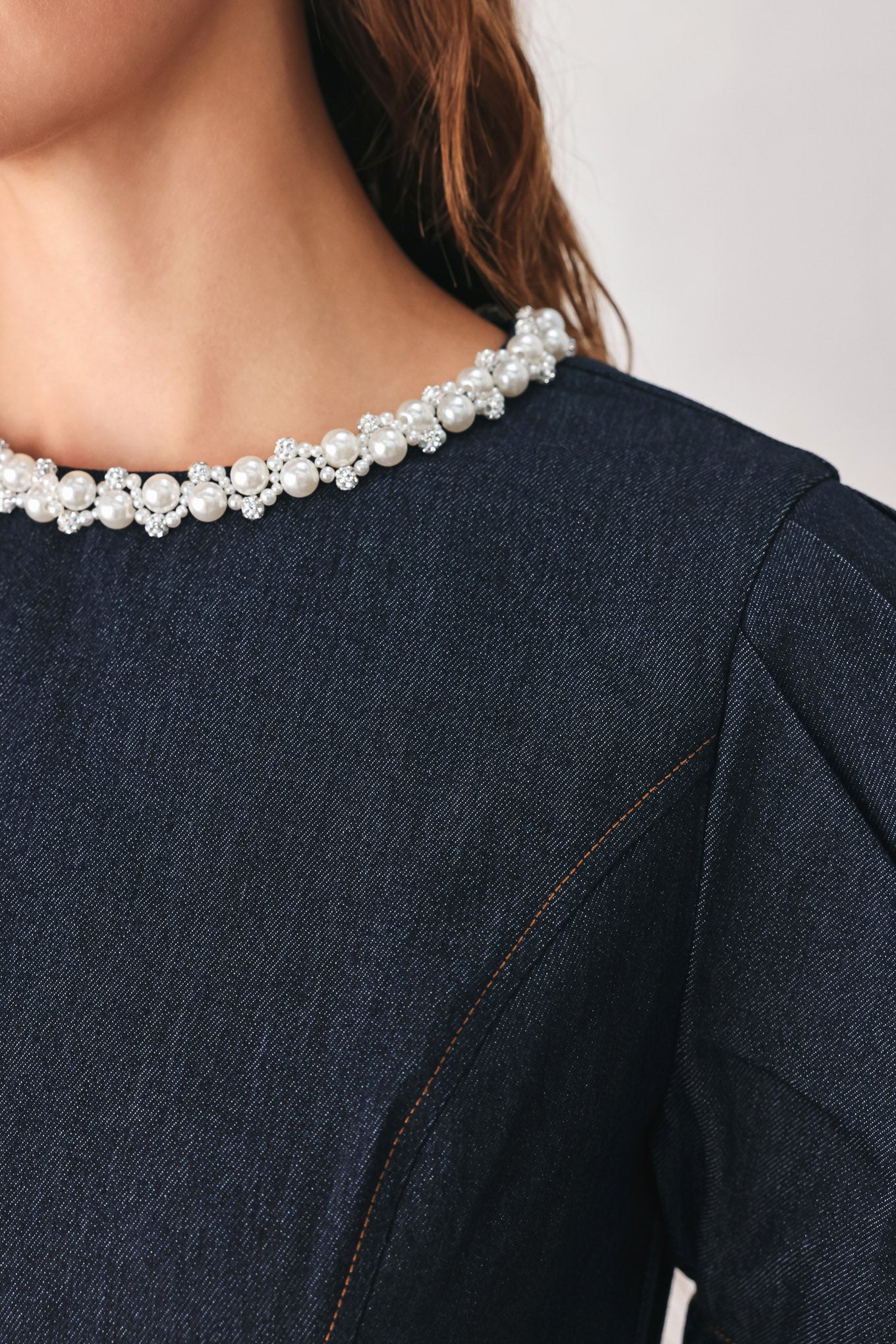 A woman wearing a dark navy blue mini dress with short puff sleeves, a round neckline accented with a white pearl collar, and a flared skirt | FREEMARKET