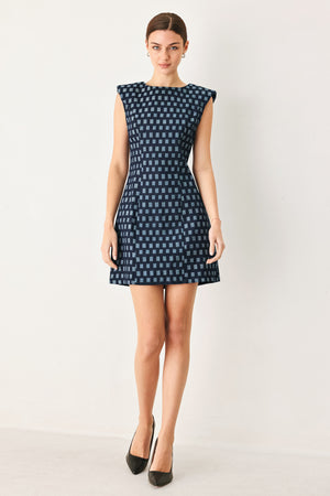 Woman wearing a denim navy patterned jacquard denim mini dress with round neckline, sleeveless and back zipper closure | Flying Tomato
