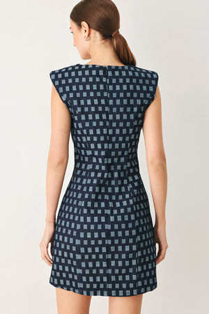 Woman wearing a denim navy patterned jacquard denim mini dress with round neckline, sleeveless and back zipper closure | Flying Tomato