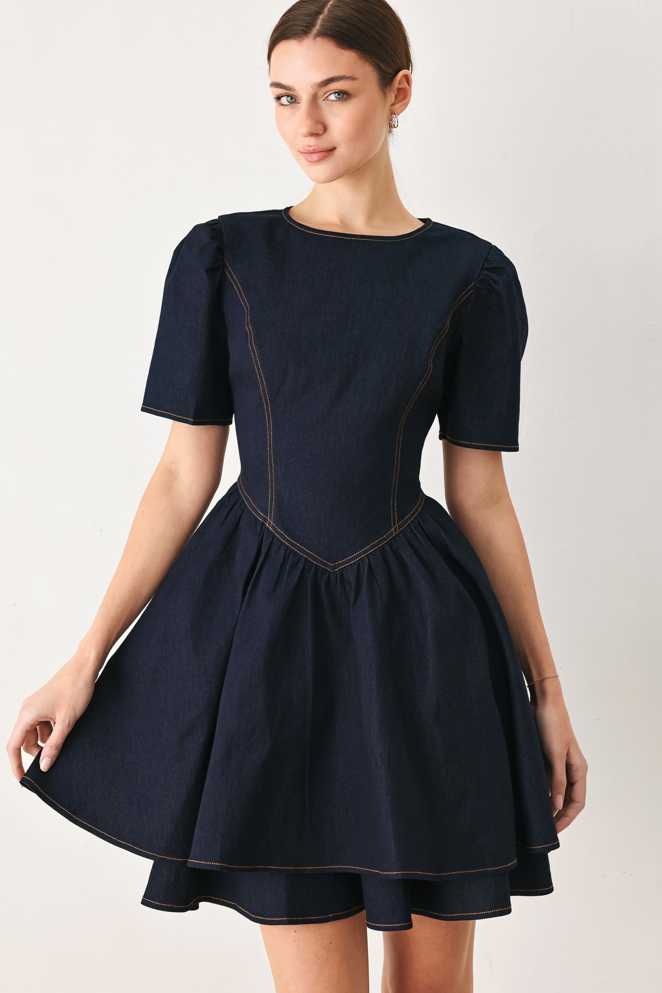 Woman wearing a dark denim navy blue mini dress featuring round neckline, short puff sleeve, basque waist, double layer skirt and back zipper closure | FREEMARKET