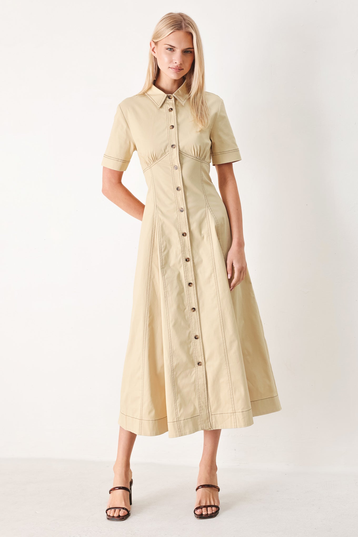 Woman wearing a khaki midi dress with front button down, short sleeve and circle skirt | FREEMARKET