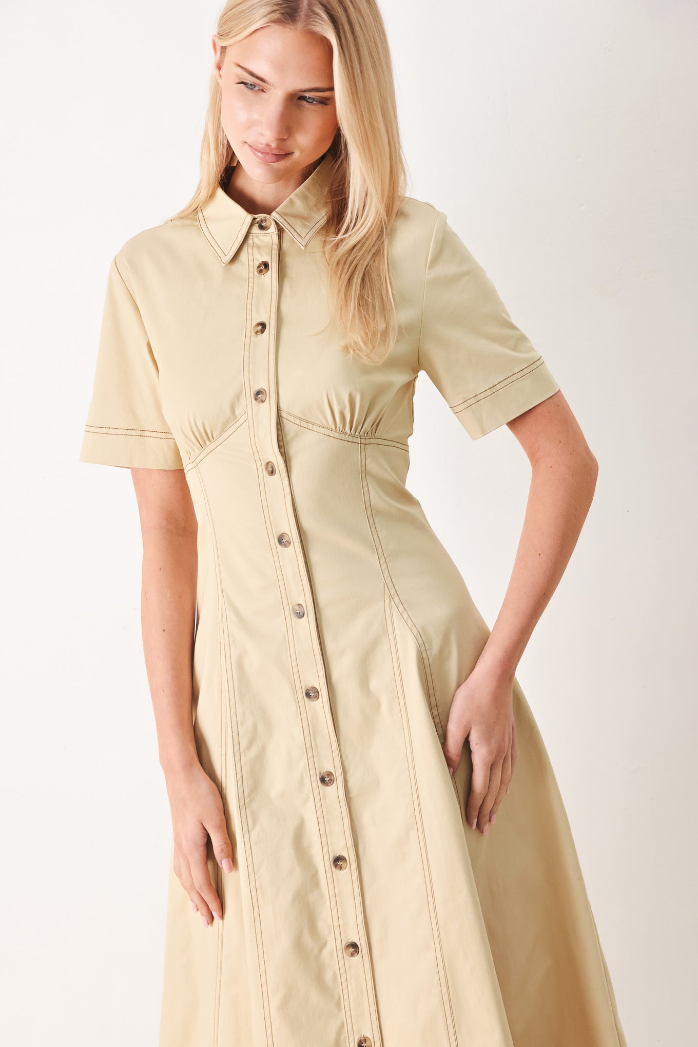 Woman wearing a khaki midi dress with front button down, short sleeve and circle skirt | FREEMARKET