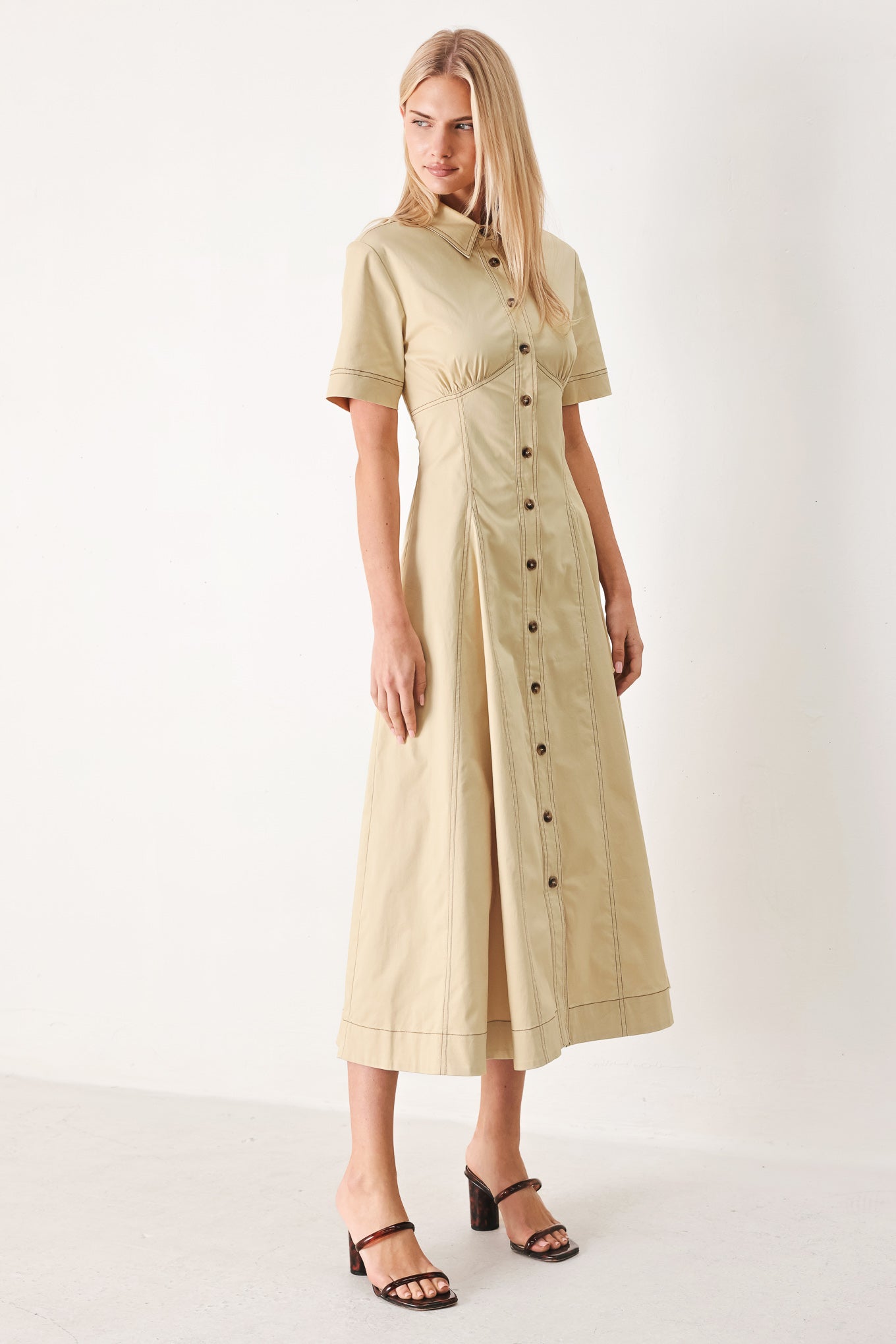 Woman wearing a khaki midi dress with front button down, short sleeve and circle skirt | FREEMARKET