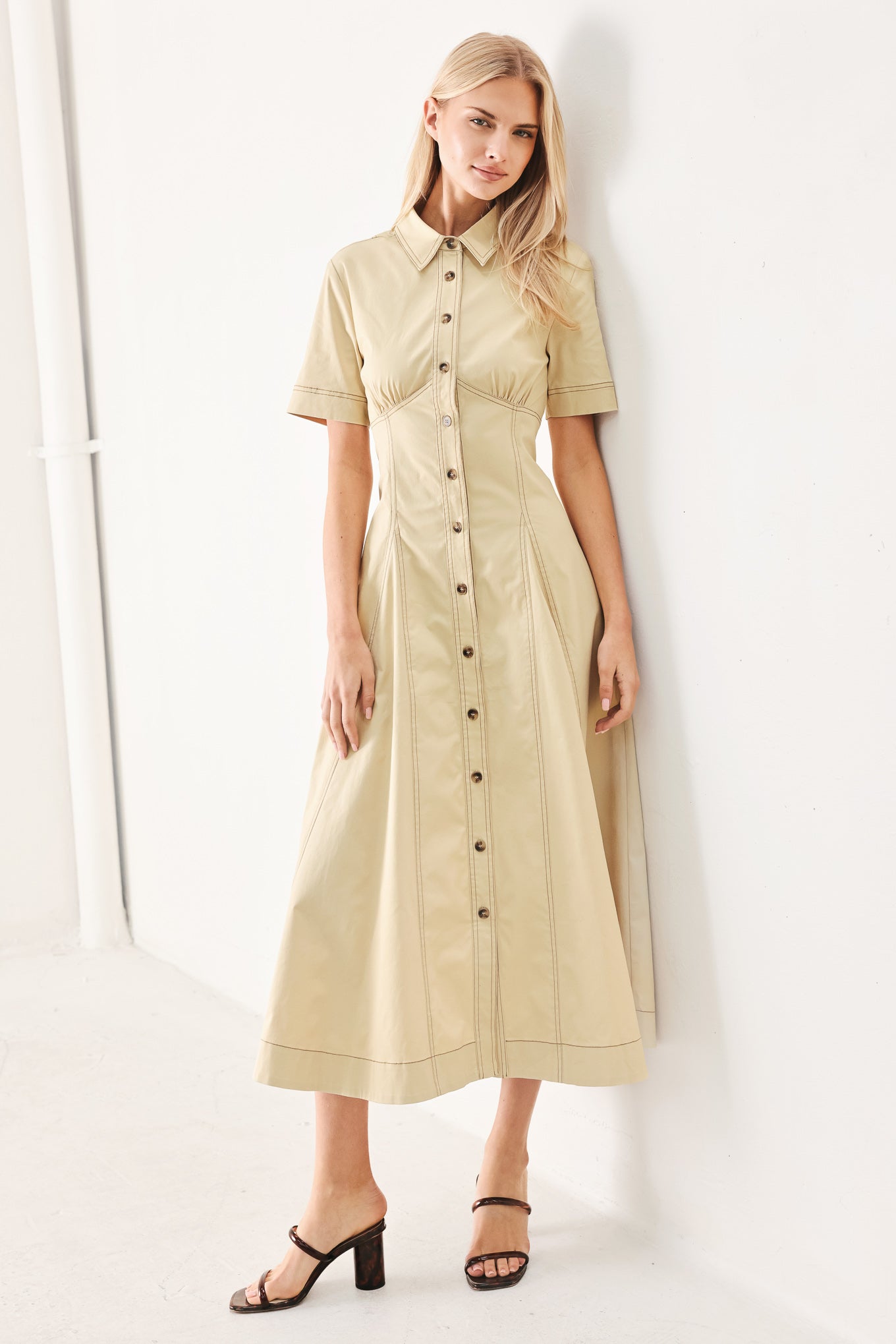 Woman wearing a khaki midi dress with front button down, short sleeve and circle skirt | FREEMARKET