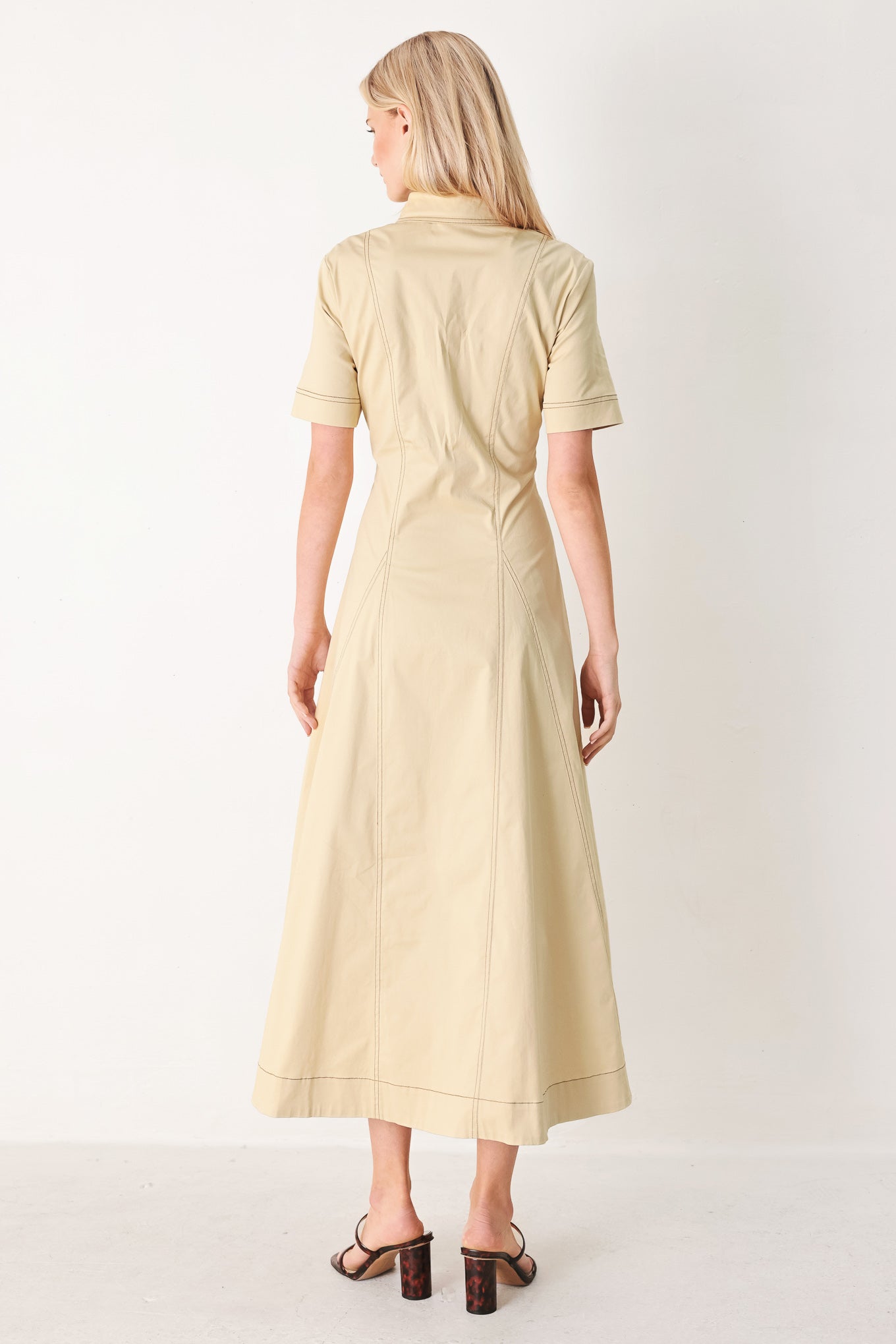 Woman wearing a khaki midi dress with front button down, short sleeve and circle skirt | FREEMARKET